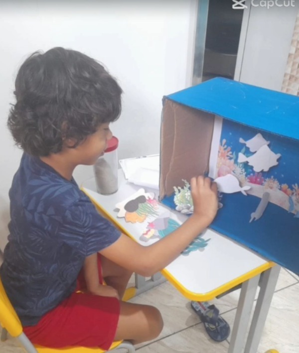 Menino pintando em atividade de reforço escolar personalizado